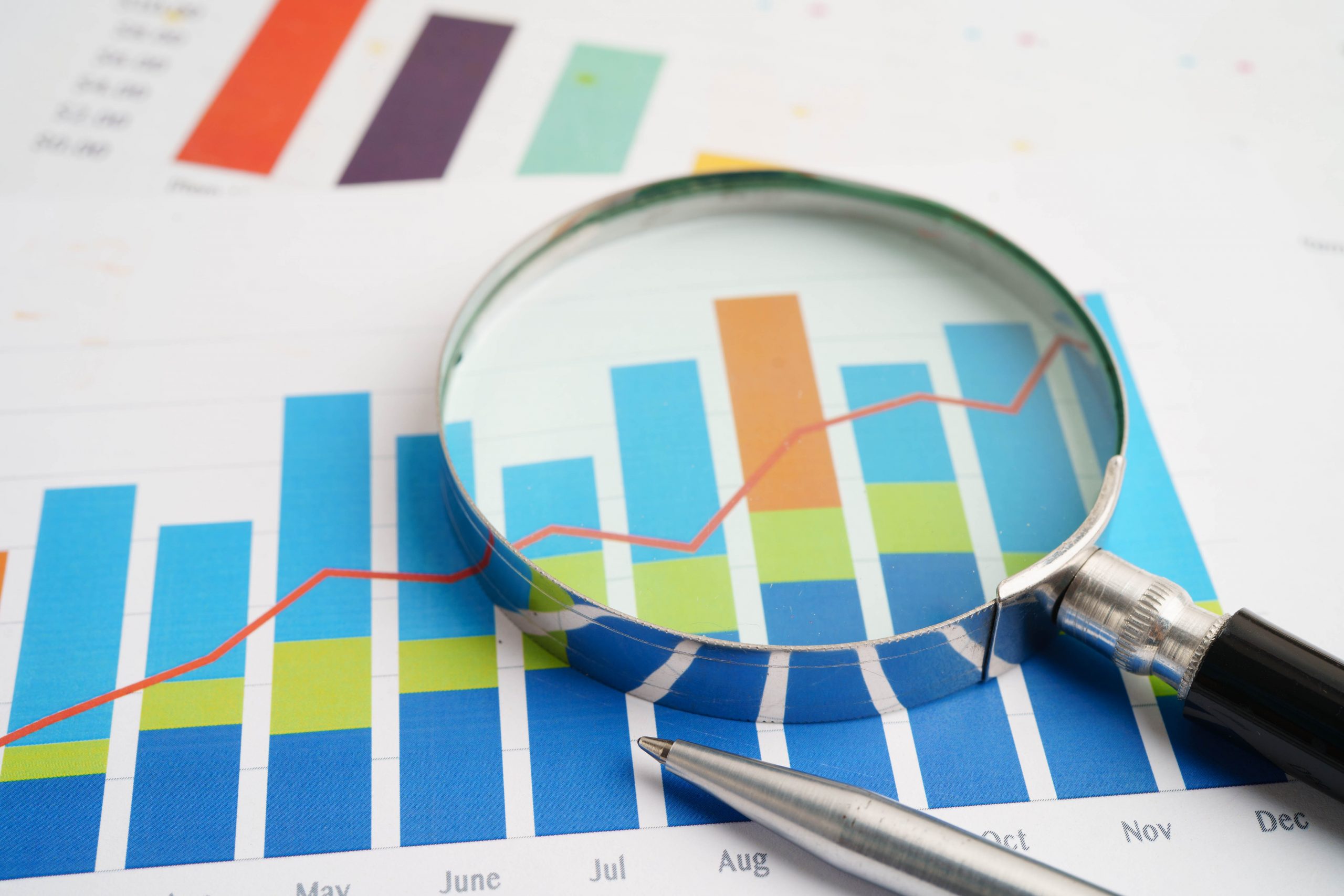 Magnifying glass on charts graphs paper. Financial development,